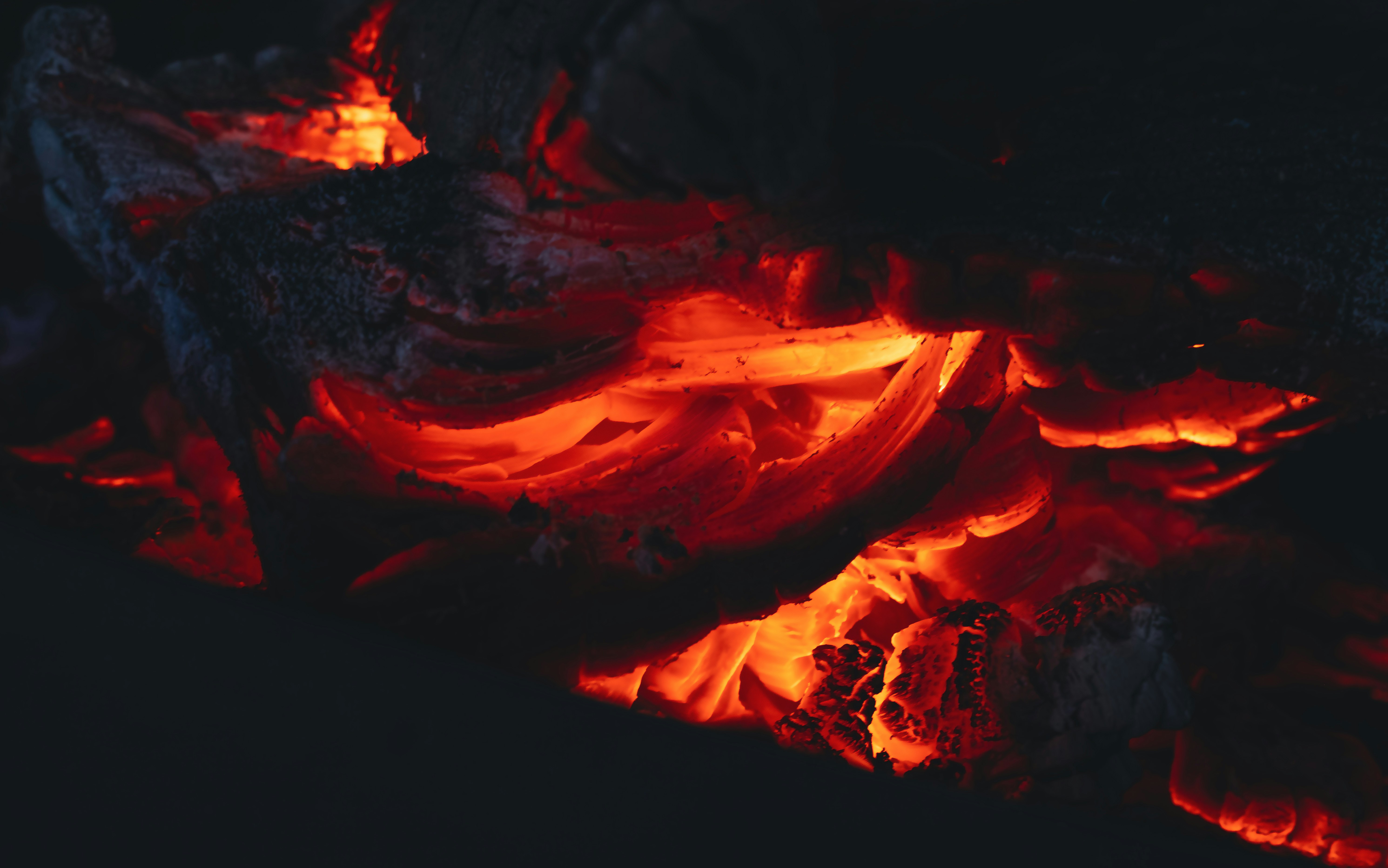 地獄谷を背景に白い噴気が立ち上る光景と遊歩道を歩く旅行者の様子