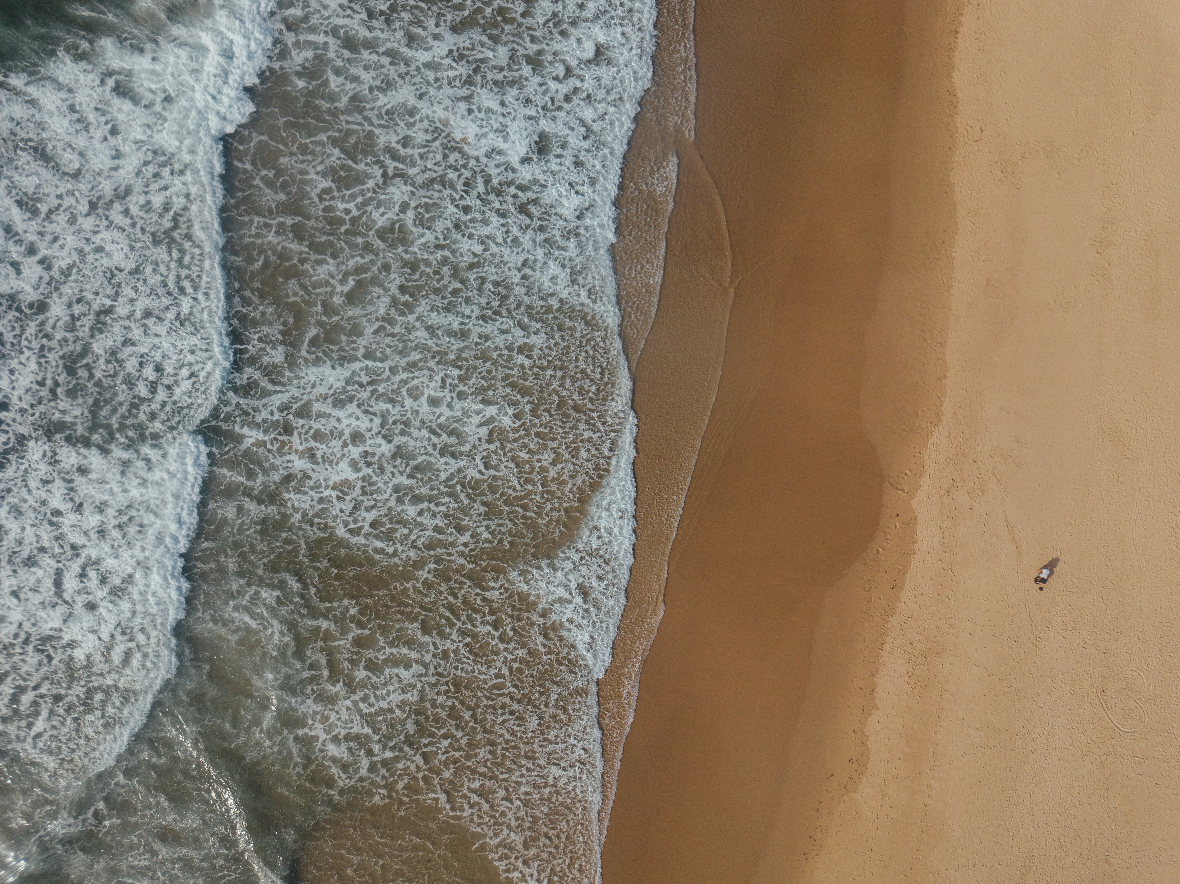 石段街を浴衣姿の人々が行き交い、夕暮れに灯る石灯籠と湯けむりが漂う風景