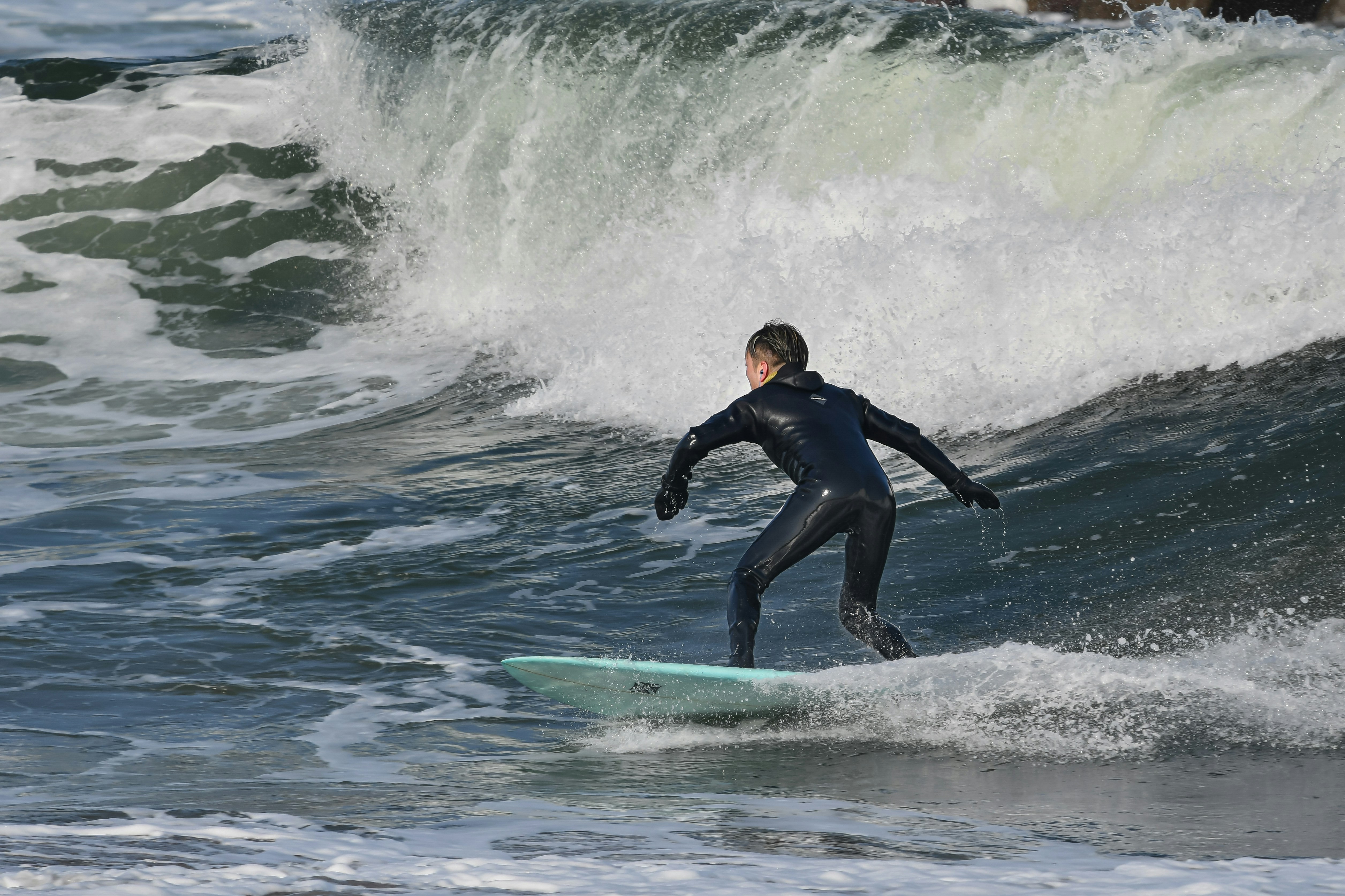 海岸沿いで砂に埋まりながらリラックスしている砂むし風呂体験の様子