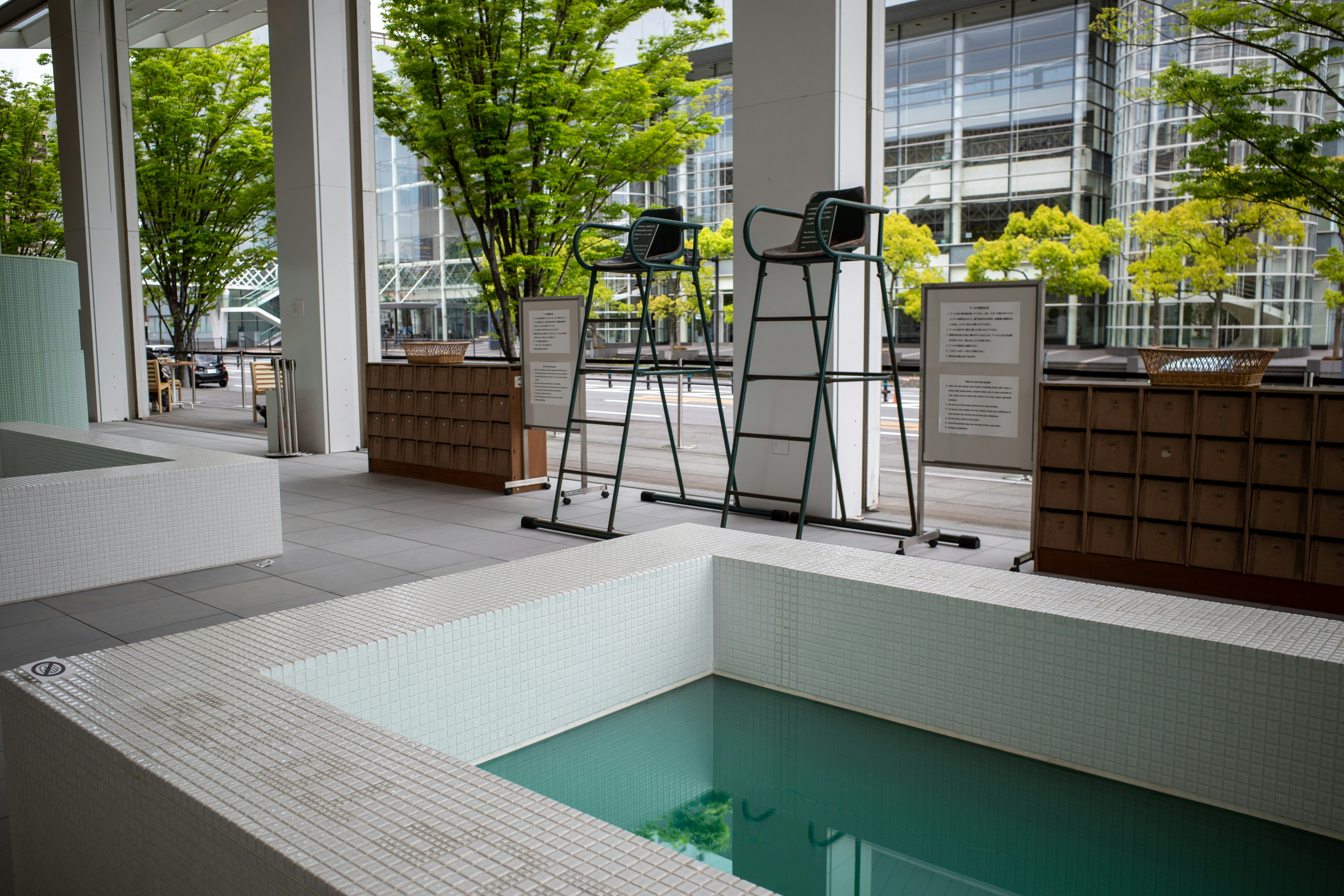 石畳の温泉街を歩く人々と、並ぶ木造の旅館や商店