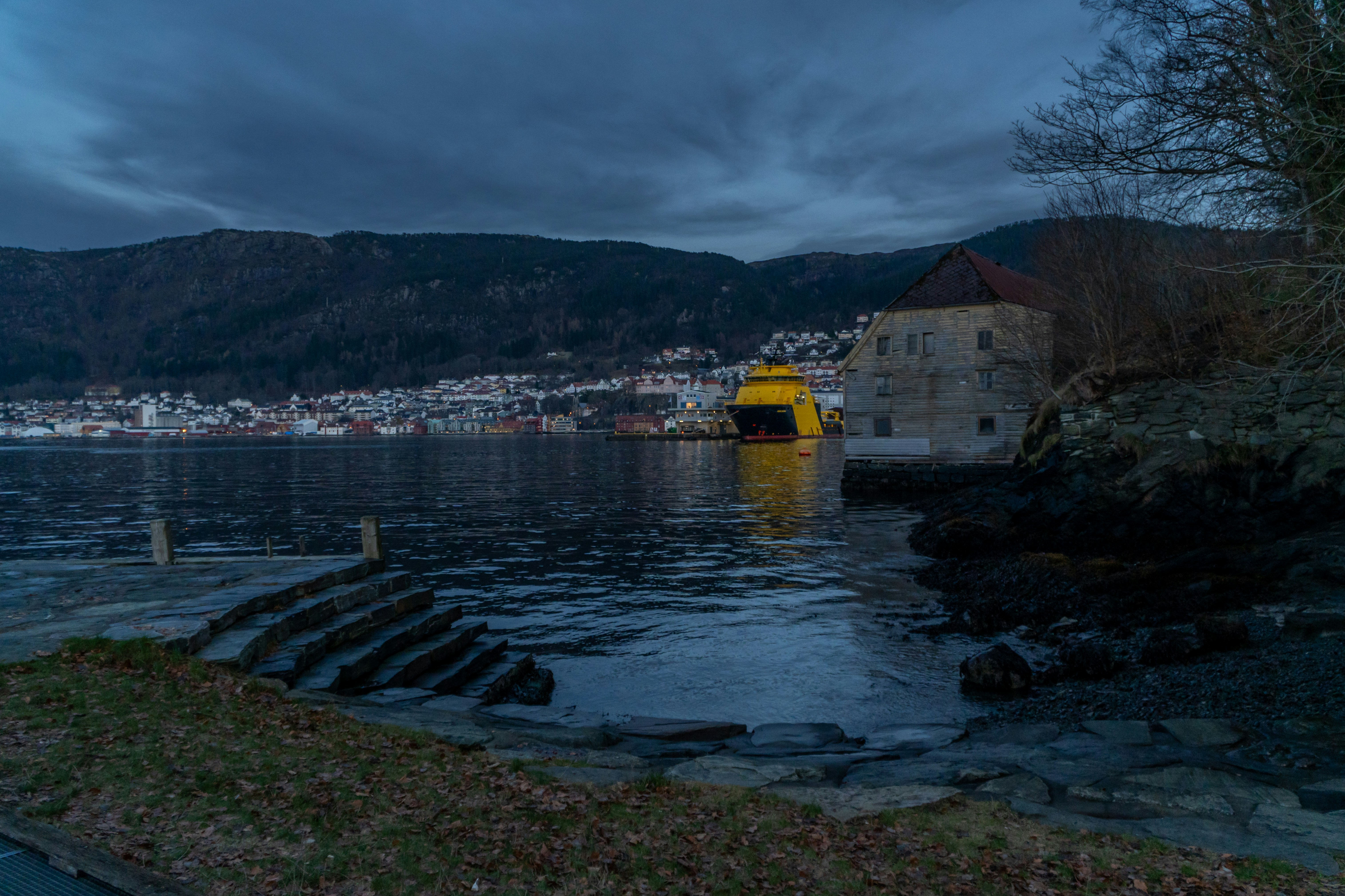 木造建築の旅館の露天風呂と、ライトアップされた庭園