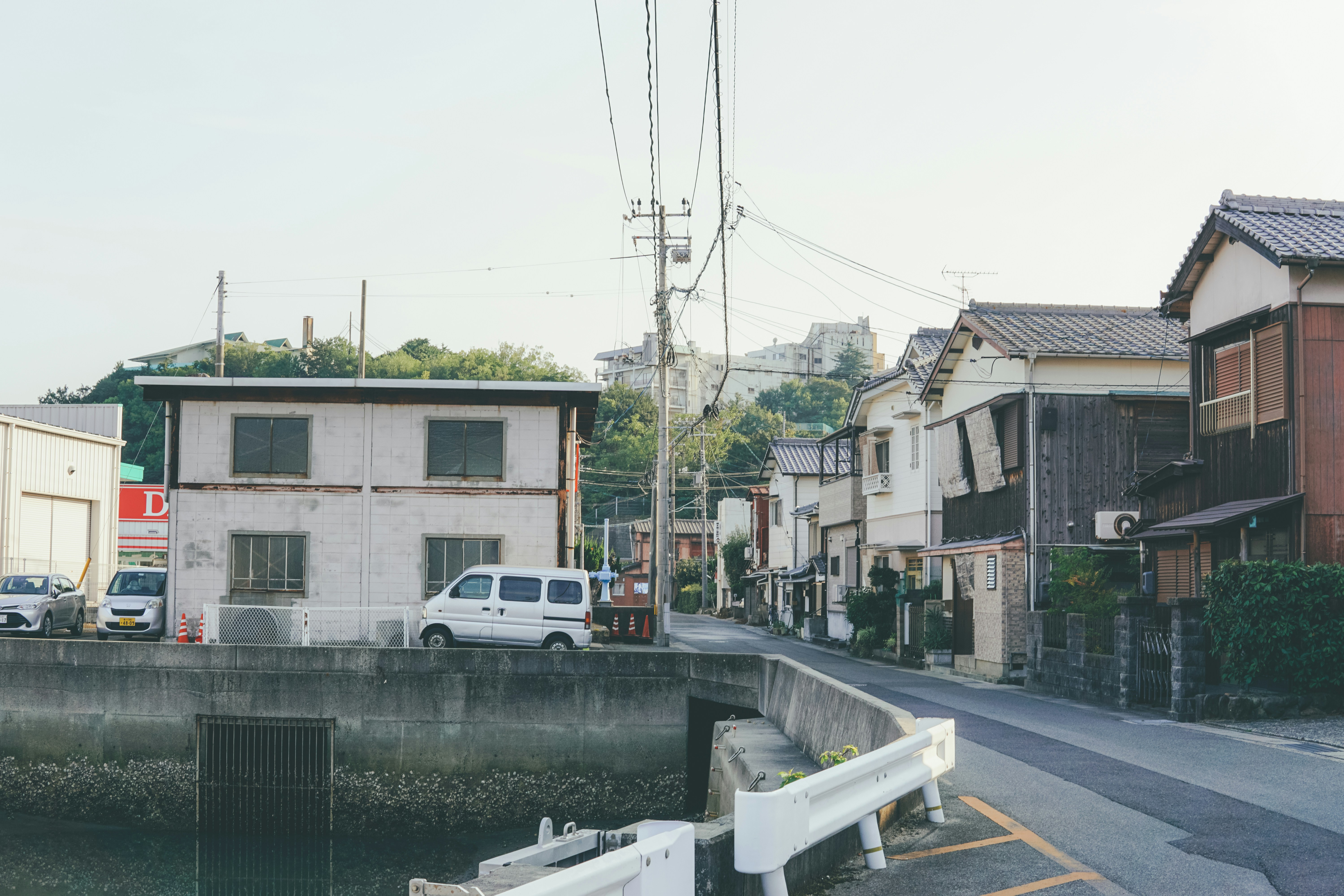 川沿いの木造旅館が立ち並び、朝もやと湯けむりに包まれる杖立温泉街の全景