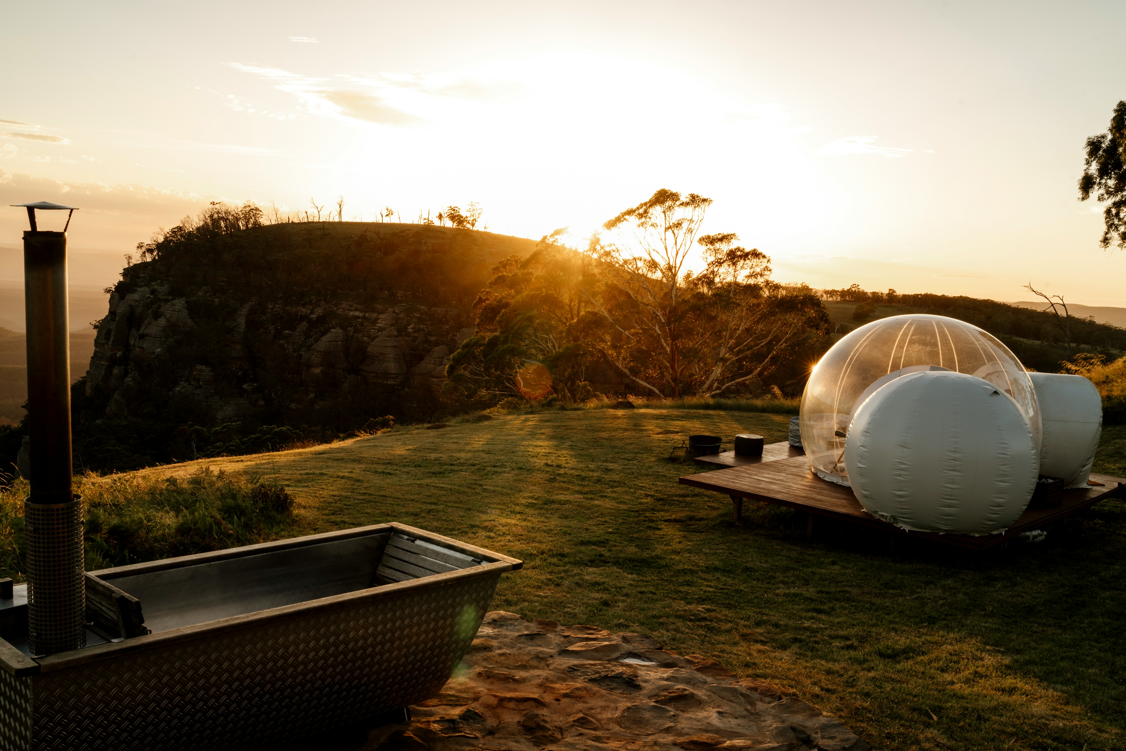 湯けむりが立ち上る奥津温泉の露天風呂とブナ林に囲まれた湯処の全景（夕方の柔らかな光の中）