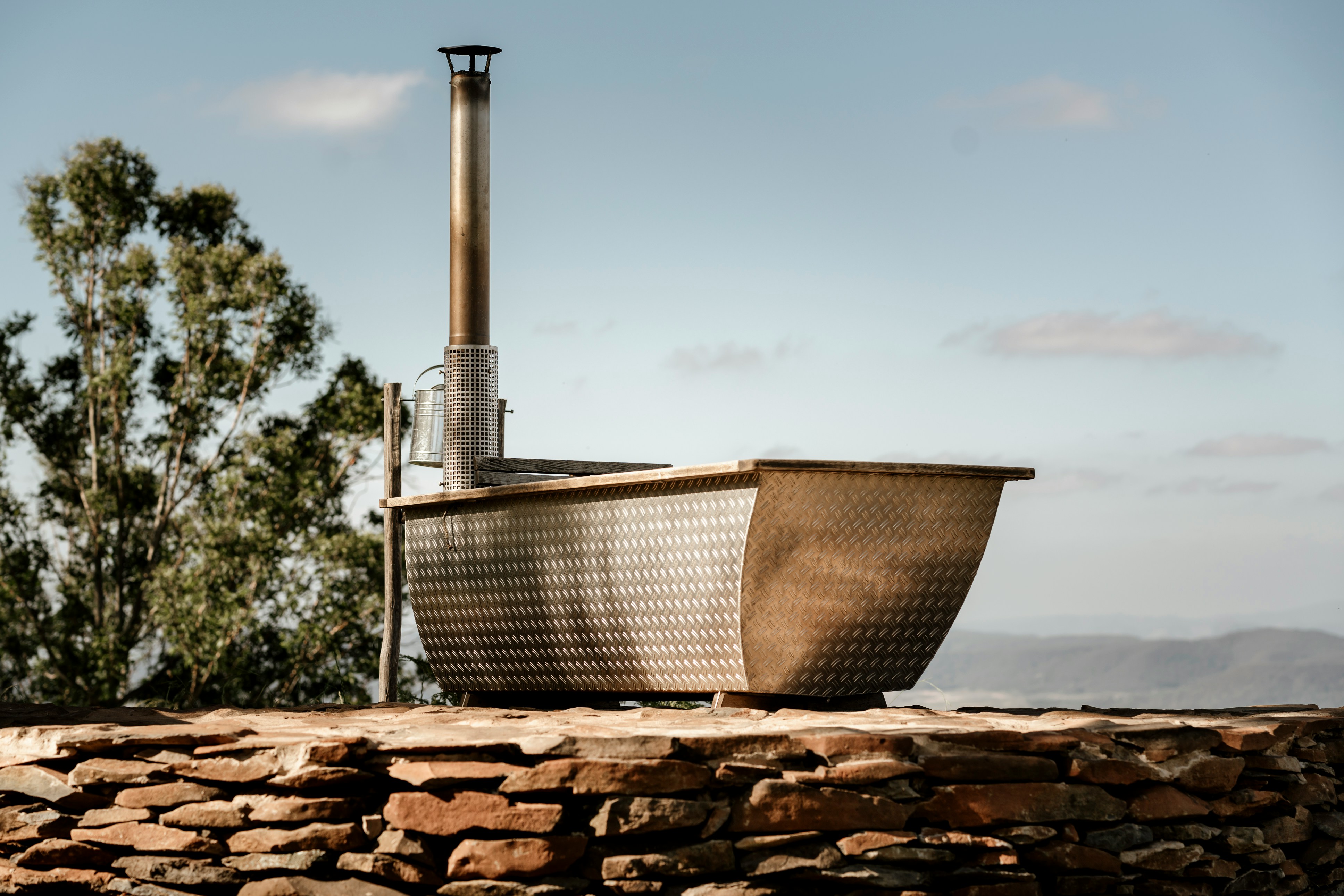 新緑に囲まれた露天風呂で、湯気が立ち上っている様子