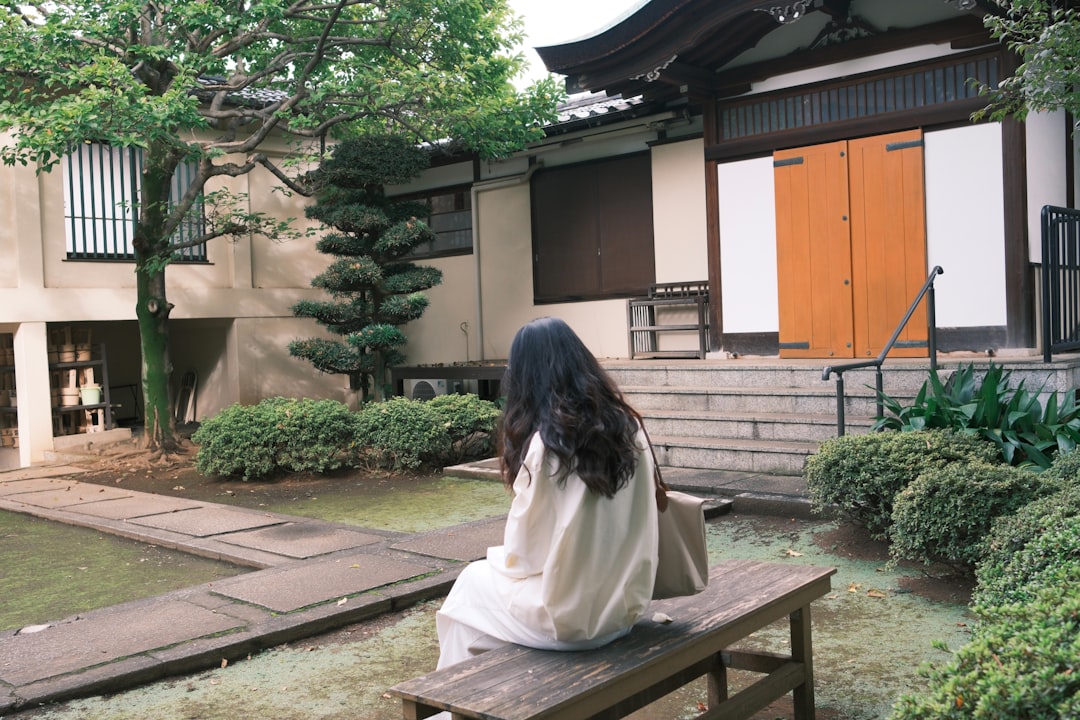 温泉街の夜道を、波柄の浴衣を着て下駄を鳴らしながら歩く男性の後ろ姿