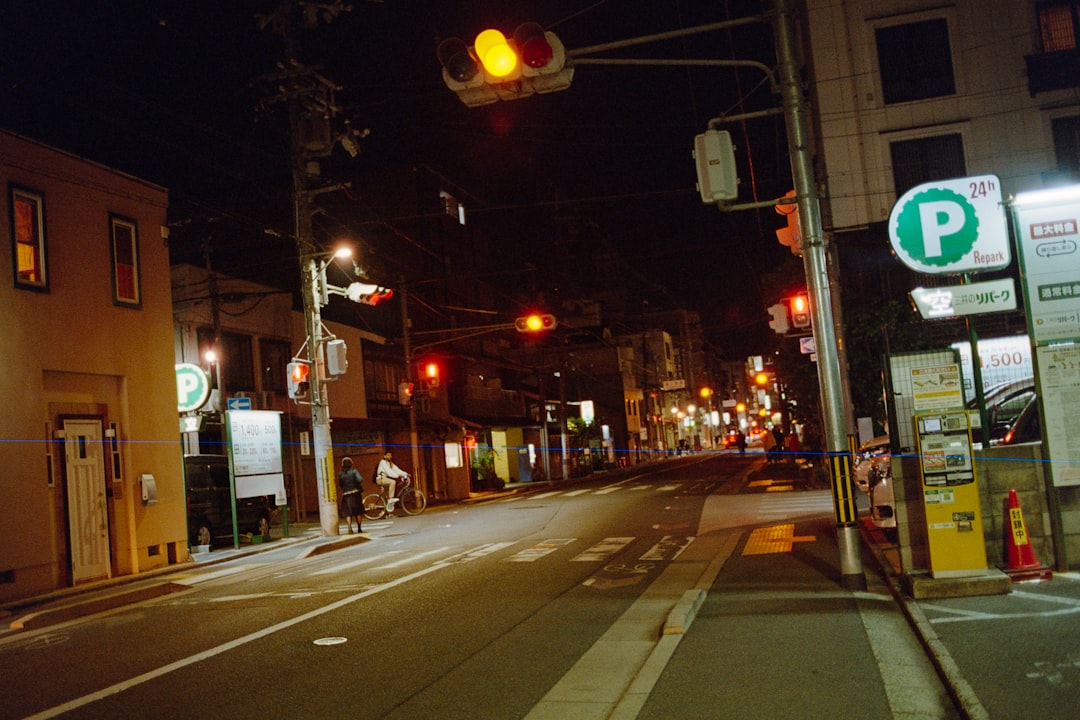 ライトアップされた温泉街の夜道を、浴衣を着たカップルが仲良く歩いている様子